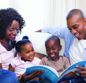 A mother and father reading to their two children.
