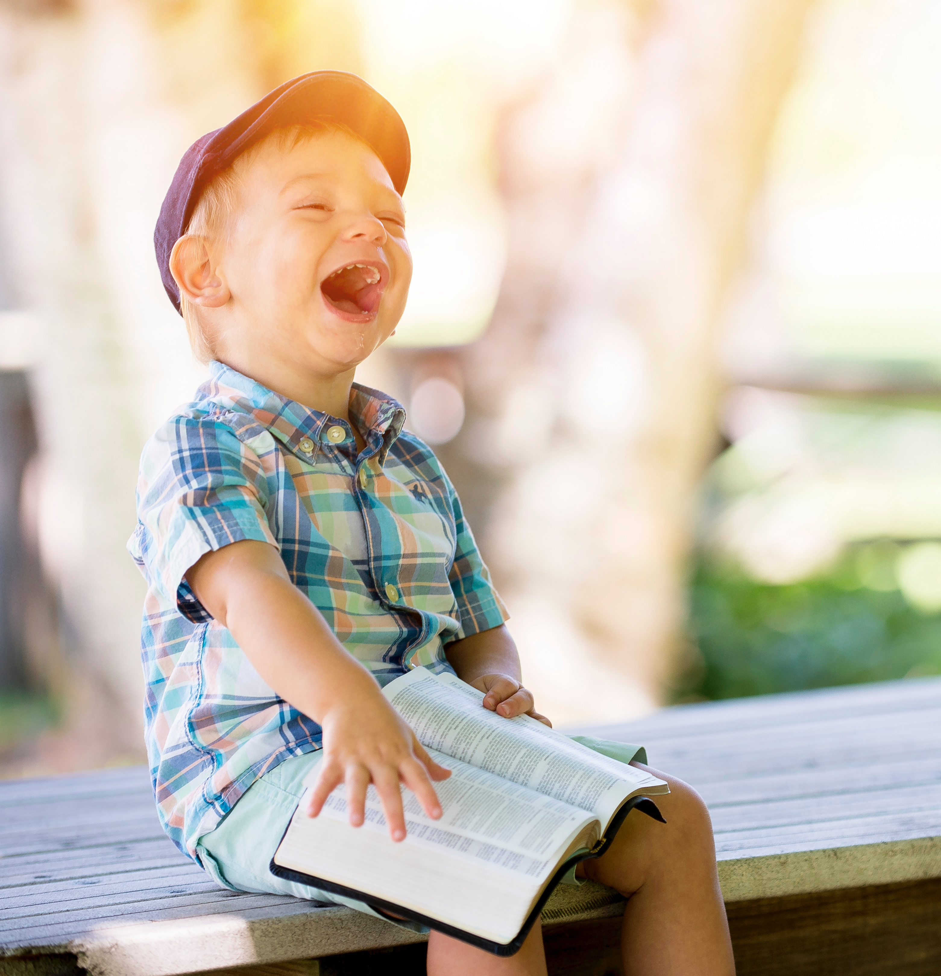 An image of a child, reading and laughing, outdoors