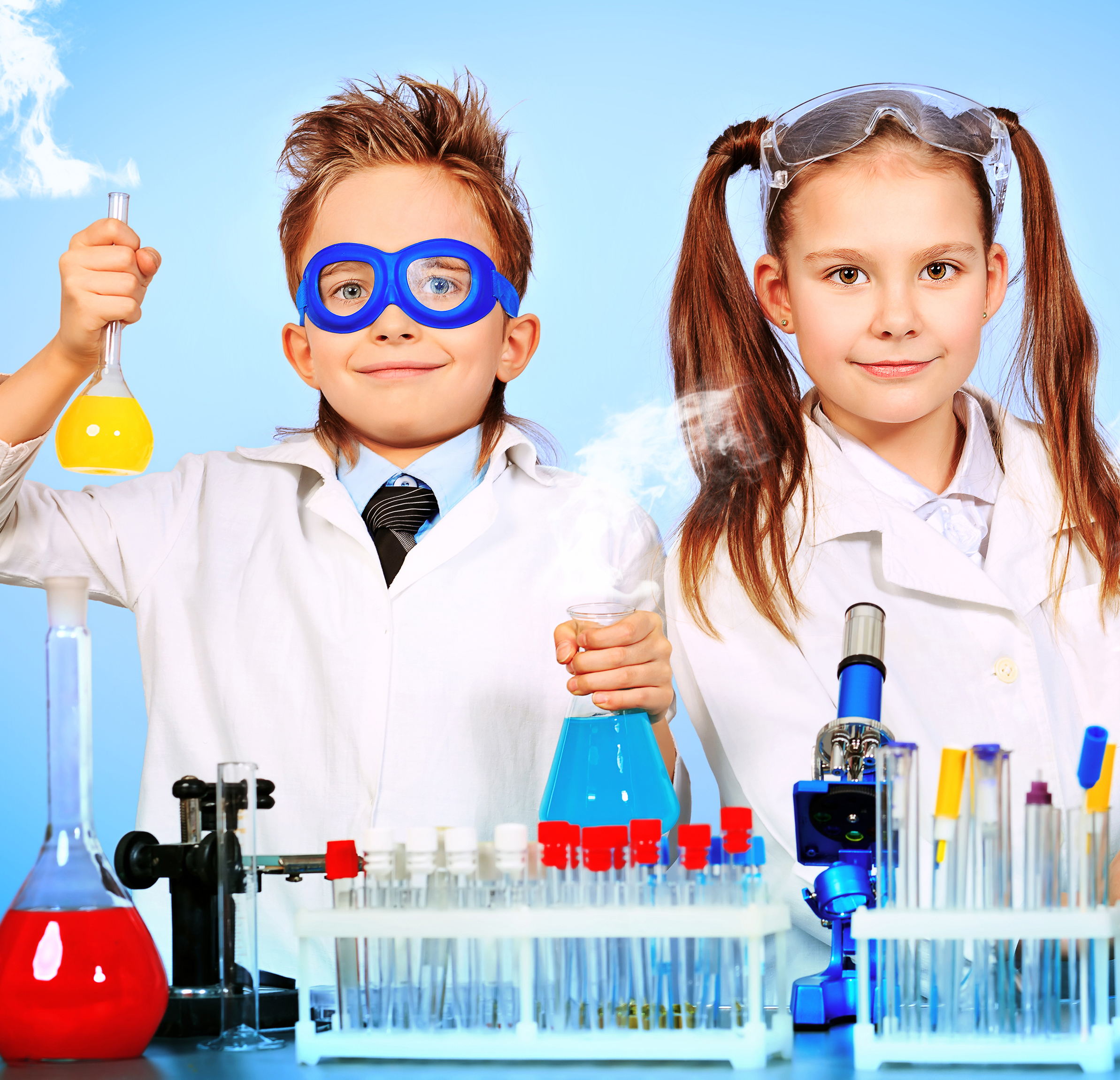 kids dressed as scientists with science lab materials around them