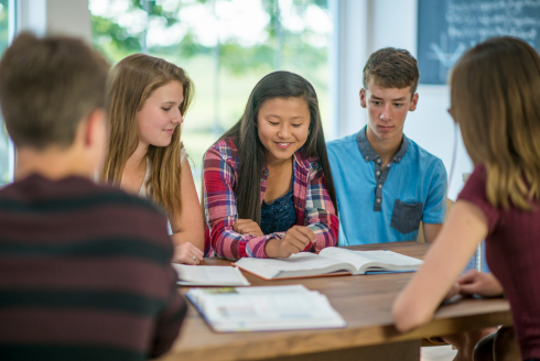 teens studying around table at the library