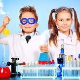 kids dressed as scientists with science lab materials around them