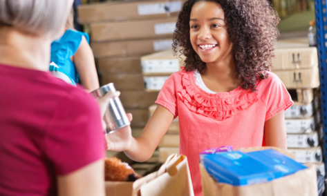 girl helping with food donations