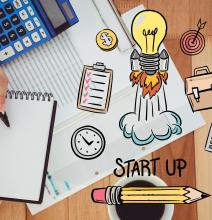Image of calculator, spreadsheet, coffee cup with line drawing of a lightbulb in a rocketship layered over top